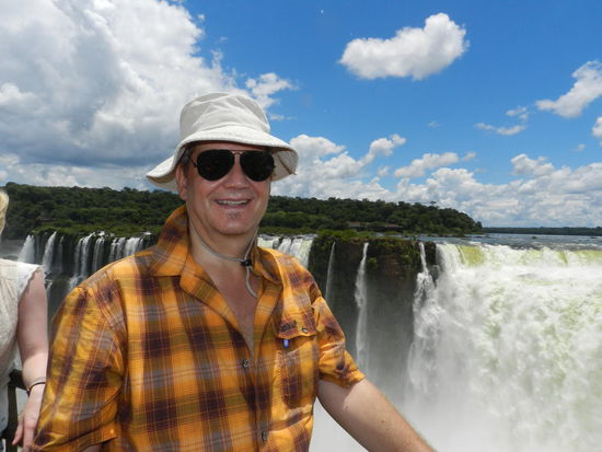 Grinsebär vor Wasserfall