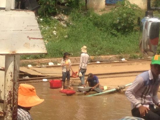 In aller Ruhe wird noch das Geschirr im Mekong Wasser gespuelt