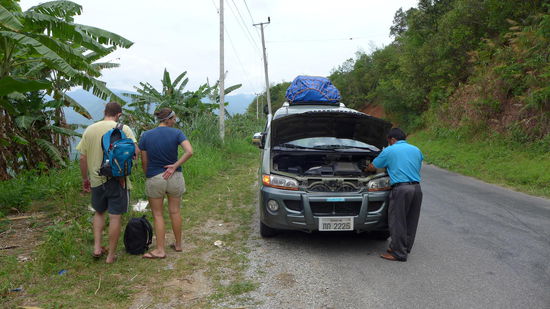 Nach ca. 1 Std. gibt es eine Zwangspause. Der Motor ist ueberhitzt und aus dem Kuehler dampft es wie aus einem alten Reiskocher. Fortan wird die Klimaanlage ausgeschaltet um den Motor zu entlasten und bei jedem Rinnsal am Wegesrand halt gemacht, um frisches Wasser in den Kuehler zu fuellen. Der sogenannte Mini-Bus ist sowieso eher ein umgebauter, schrottreifer Hundai Familienvan und die 11 Fahrgaeste mit westeuropaeeischer Statur sitzen ziemlich zusammengefaltet auf den Kunstledersesseln.