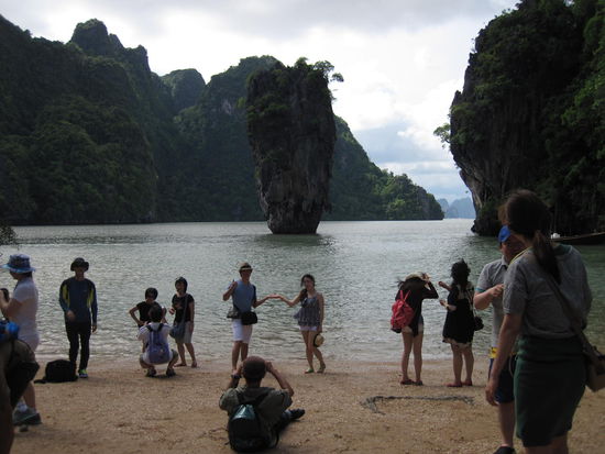 Khao Phing Kan (wörtlich schiefer Felsen) ist eine Insel in der Bucht von Phang Nga im Süden Thailands, bekannt geworden als James-Bond-Insel. 1974 landete Roger Moore als Geheimagent ihrer Majestät im Film "Der Mann mit dem goldenen Colt" vor der beeindruckenden Kulisse der Insel.
Heute landen unzaehlige Touristenboote dort und man muss sich an dem kleinen Strand vor der Felsnadel anstellen, wenn man den Fotozirkus mitmachen will.
