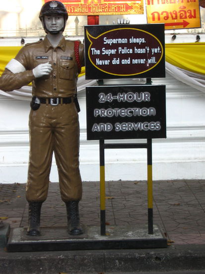 "Der Superbulle schäft nie." Diese Statue steht vor der wohl korruptesten Polizeistation Thailands am Ende des Touristen-Ghettos Khao San Road. Direkt dahinter ist der vergleichsweise reiche Wat Chana Songhkram.