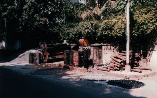 Straßenbau a la Inde: Unter den Teerfässern (Mitte) brennt ein Feuerchen. Mit dem angelieferten Kies wird dann von Hand die Masse gerührt und auf die Starße gegossen, dann von Hand festgeklopft.
In Gangtok sah ich eine Teermaschine wie sie bei uns üblich ist. Die verursachte einen Volksauflauf (und macht mindestens 5 Leute arbeitslos).