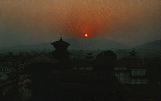 Blick über Kathmandu zum Sonnenuntergang (der regelmäßig um diese Zeit stattfindende 1-1½stündige Stromausfall macht derartige, nicht durch Straßenbeleuchtung verschandelte, Bilder möglich).