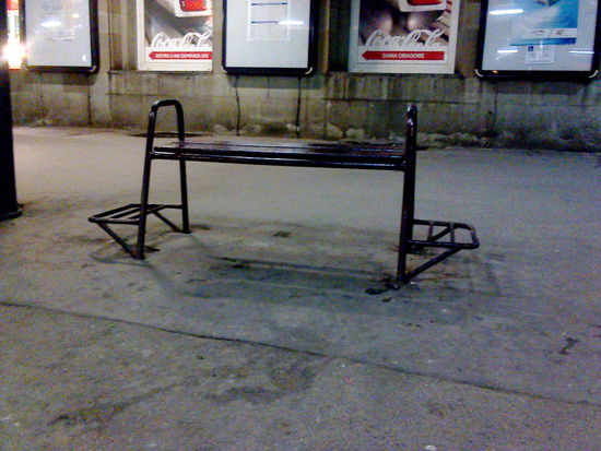 Sitzbank im posener Bahnhof -- praktischerweise kann man sein Gepäck auf die Gestelle an der Seite stellen und muß es nicht in den Dreck werfen.