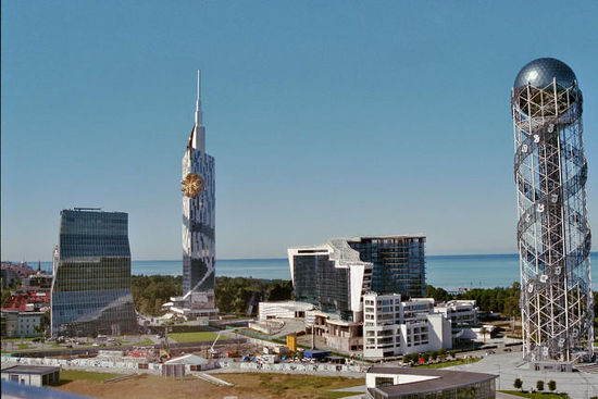 Blick über die Neubauten am Hafen von Batumi, finanziert von "internationalen Finanzinvestoren." Rechts der Alphabet Tower, die 33 Buchstaben des georgischen Alphabets darstellend. Nachts alles schön angestrahlt. (Aufnahme aus dem Riesenrad heraus.)