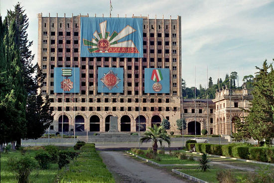 Das innen vollkommen zerstörte ehemalige Regierungsgebäude des Sowjets (Gute Photos des Inneren von 2012). Die Symbole feiern die 20jährige "Unabhängigkeit" d.h. die Existenz eines Staates der russische Kolonie ist.