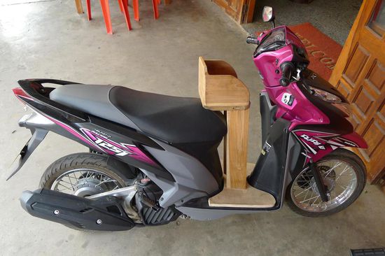 Vorher noch nie gesehen: ein Kindersitz fürs Moped! Normalerweise werden die kleinen Racker zwischen die Knie oder unter den Arm geklemmt oder so