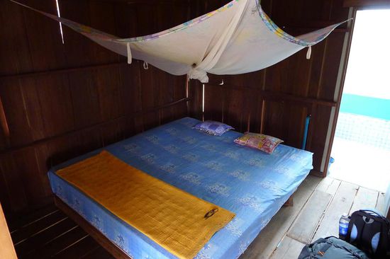 Unser doch sehr spartanisches Zimmer. Eine Holzbaracke mit löchrigen Wänden und Boden. Das Bett war sauber, hatte ein intaktes Moskitonetz und einen Anbau-Verschlag als Bad gab es auch. Das nennt man leben wie die Locals.