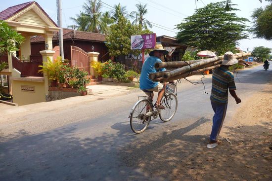 Eine wunderbare Fahrradtour beginnt, vorbei an Lasten tragenden (Bambus) Männern