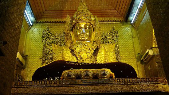 In der Mahamuni Pagode, ein weiteres wichtiges Heiligtum. Der Buddha ist mit soviel Blattgold beklebt, dass man kaum noch Konturen erkennen kann