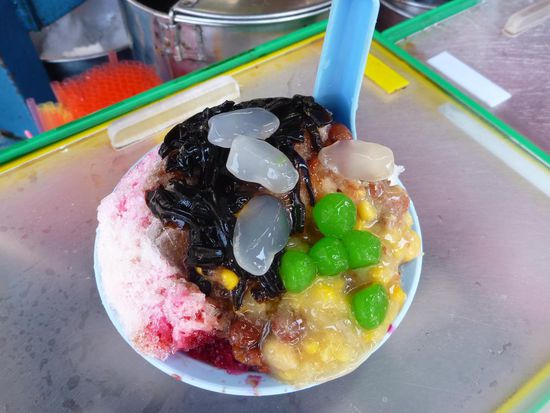 Ais Kacang, geschreddertes Eis mit buntem Sirup,buntem Glibber und natürlich roten Bohnen und Mais. wird oft zum "Herunterkühlen" genutzt aber nur an besonders heissen Tagen , also täglich !