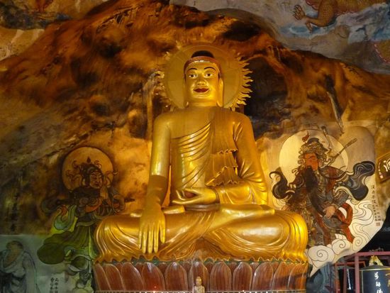 Ein grosser sitzender Buddha, überall auch farbenprächtige Wandmalereien