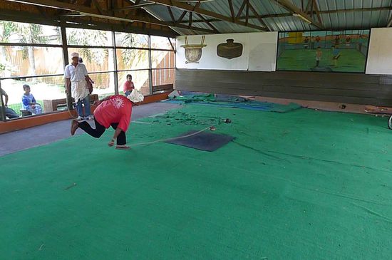 Gasing Pangkah, ein Sport bei dem ein Kreisel auf der markierten Fläche durch ein Seil in Bewegung gebracht wird. Der Gegner versucht mit seinem Kreisel den schon sich Drehenden von der Fläche zu schubsen ohne diese selbst zu verlassen. Es treten mehrere  Mannschaften gegeneinander an