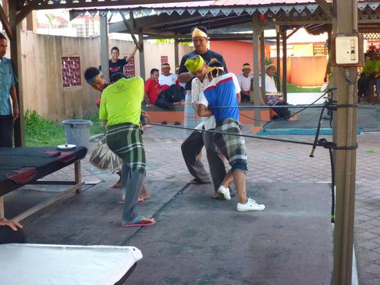 Mit vollem Körpereinsatz wird das Seil straff um den Kreisel gewickelt um eime möglichst hohe Geschwindigkeit zu erzielen