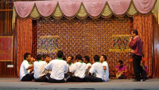 Dikir Barat, im Hintergrund die begleitenden Trommeln, ein einzelner Sänger singt den Text vor....