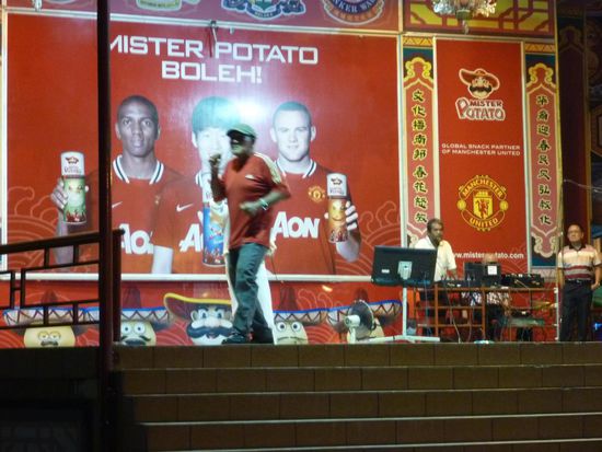 Am Wochenende gibt es dann auf einer grossen Bühne "Senioren-Karaoke". Der rüstige Senior im Bild begleitete a l l e Sänger/innen bei
j e d e m Lied mit Tanz und Luftgitarre-Spiel. Einfach unglaublich, machte total Spass zuzusehen, nicht nur uns, der Platz war richtig gut besucht.