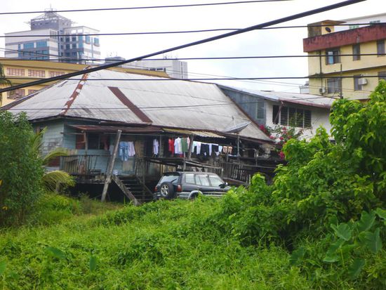 Etwas außerhalb sieht man Häuser die kurz vor dem Zusammenfallen sind, aber es wohnen Leute darin