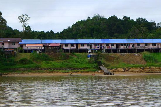 Am Flussufer stehen überall die berühmten Langhäuser, allerdings in moderner Version