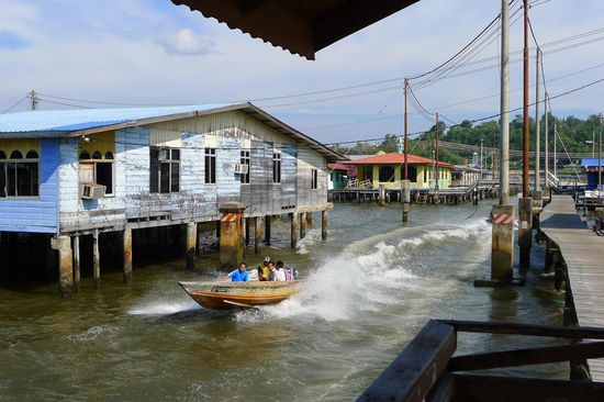 Taxiboote fuhren mit einer unglaublichen Geschwindigkeit zwischen den Stelzenhäusern herum