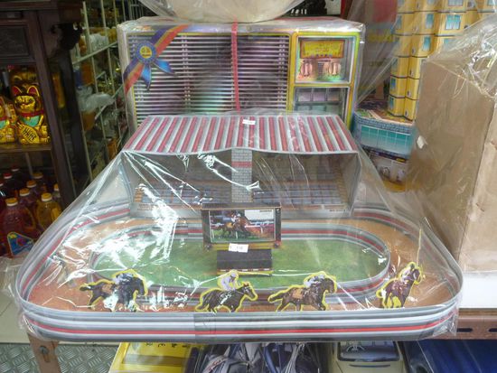 Als Opfergabe kann man alles was man so im Leben braucht aus Papier hergestellt kaufen. In diesem Fall sogar eine Pferderennbahn!
Wetten beim Pferderennen ist sehr beliebt in HK,darauf möchte man auch in anderen Welten nicht verzichten.