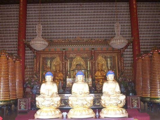 Überall entlang der Wände und in runden Aufstellern unzählige winzige Buddha Figuren