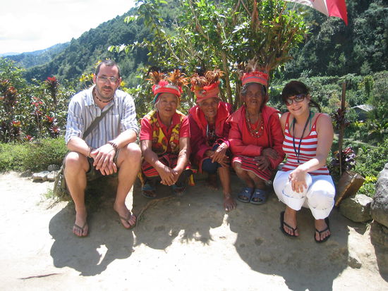 ifuago indianer in ihrer traditionell rot-weiss oder blau-weiss gestreiften tracht! dazwischen 3 junge touristinnen! 