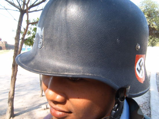 Nun, das ist ein Mopedhelm. Wir fragen uns warum manche hier sehr offensichtlich Hakenkreuze und anderes aus dem Dritten Reich moegen. Leider kann uns dieser junge Mann auch keine Auskunft geben. Er spricht kaum Englisch.
Anmerkung des Webmasters:
Das Hakenkreuz ("Swastika") ist in vielen buddhistischen Laendern ein heiliges Symbol! Soviel zur Erklaerung 
Viele Gruesse,
Martin