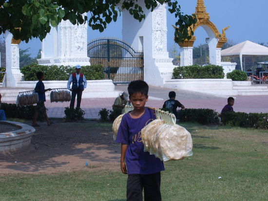 Ein Junge verkauft duenne Fladenbrote. Wie in Burma muessen auch hier viele Kinder zum Lebensunterhalt der Familien beitragen.