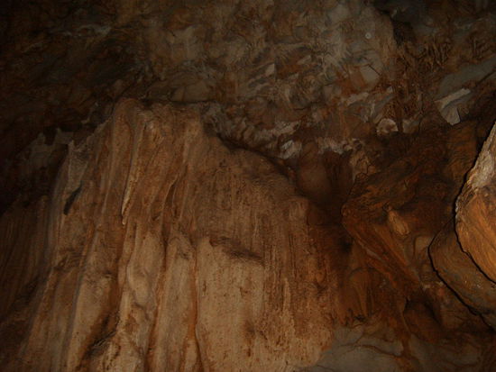 Die Stalaktiken klingen wie Trommeln. Der Boden der Hoehle ist teils auch hohl. Wir bekommen eine wasserdichte Taschenlampe mit Akku (wird um den Hals gehaengt) damit wir in keinem Loch verschwinden. An den Waenden kleben grosse Spinnen mit gestreiftem Koerper und einige Fledermaeuse lassen sich auch sehen.