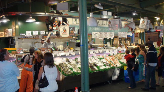 Nicht immer landet der fliegende Fisch dort, wo er landen soll: Fish Thrower auf dem Pike Place Market werfen sich die Fische über die Ladentheke zu.