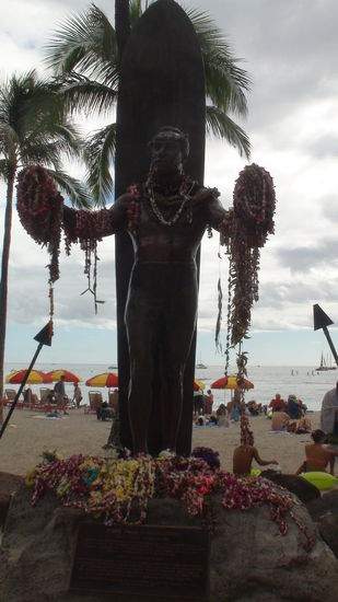 Statue des Duke Kahanamoku mit Leis geschmückt. Der Duke gilt als Begründer des modernen Wellenreitens, in den 20er Jahren war er mehrfacher Olympiasieger im Schwimmen