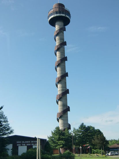 Der Aussichtsturm auf Hill Island bei den 1000 Islands. Wir standen schon morgens um 9 Uhr bei Öffnung vor der Tür und lösten das Ticket für den Lift (22,49$ für 2 P.). Herrlicher Ausblick!
Nach 1 1/2 Std. fuhren wir runter und wurden auf Deutsch angesprochen 'Na, Ihr habt es aber lange oben ausgehalten!'
Den Turm hat ein deutsches Paar gekauft die halt auswandern wollten.
Die Zeit für ein intensiveres Gespräch fehlte und die direkte Frage war wohl zu persönlich:
'Was ist hier soviel besser als in Deutschland, Schweiz usw.?
Wir würden bisher nie auf den Gedanken kommen nach Kanada auszuwandern! Unserer Meinung nach gibt es nichts was hier besser wäre als bei uns! Gregor brachte es mal wieder knapp genug auf den Punkt:
7 Monate Winter bei 20 Grad minus und mehr, 2 Monate Stechmückenplage, keine gemütlichen Kneipen und teure Lebenshaltungskosten!
Und wenn Touristensaison ist kann man die schöne Inselgegend hier nicht geniesssen weil man arbeiten muß und wenn die Saison vorbei ist und der Turm geschlossen wird ist Winter!