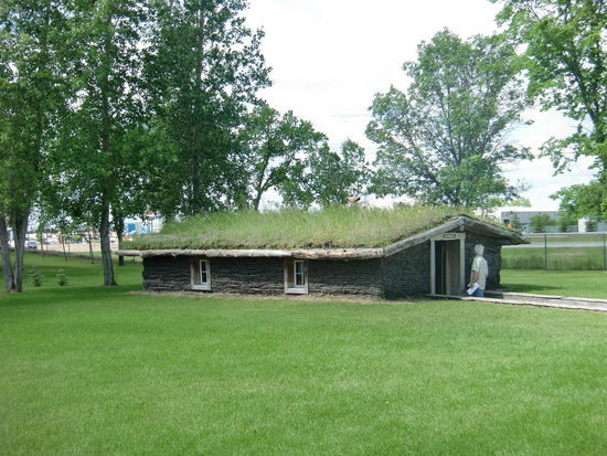 Das Semlin-Haus war äußerst beeindruckend. So bauten die ersten Siedler ihre Häuser: Man hob ein 1m tiefes Loch aus mit 4 m Breite und 12 m Länge und legte entlang dem Aushub eine 1m hohe Isolierschicht aus Grassoden. Das Dach besgtand aus Holzbalken mit Lehm/Dung-Mixtur und bedeckte alles wieder mit Grassoden. So bildete das Haus nur eine kleine Unebenheit in der Prärie und im Winter fegten die Blizzards und im Sommer die Feuer darüber hinweg.
Einfach genial!