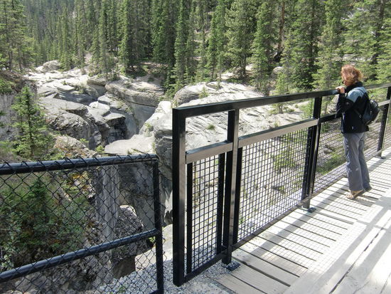 Am Mistaya Canyon: Höher kann man einen Zaun nicht anbringen! Da muß ich mich schon auf die Zehenspitzen stellen oder den Rücken krumm machen und unten durch gucken!
Am Ende der Brücke war dann gar keine Absperrung mehr und Gregor entdeckte einen Weg nach unten auf die Felsen des Canyons.