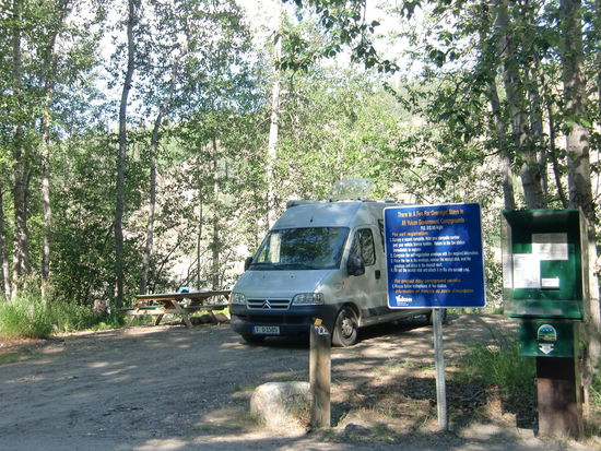 Am anderen Ufer des Yukon gegenüber von Dawson City:
Wir hatten unseren Stellplatz direkt hinter der Self-Registrierung und der Box in die man das Übernachtungsgeld wirft.
Gregor und ich saßen gerade in unserem Auto und tranken Kaffee und aßen Cinnemon-Bun. Da kam eine Amerikanerin und fragte:' You are the Rangers?' Sie hatte kein Kleingeld und wollte wechseln!
Gregor verschlägt es ja selten die Sprache! Als er sie dann wiederfand:' Die muss doch total blöde sein! Sieht so ein kanadisches Rangerauto aus? Und die Ranger sitzen dann drin und trinken Kaffee und essen Kuchen?
Er grübelte weiter nach und kam zu einer - wenigstens kleinen - Entschuldigung!
Wir hatten zufällig beide unser Nepal-T-Shirt an auf dem oben links ein Logo aufgedruckt war mit Everest-Treck und der Abbildung eines Bergmassivs! Nun ja!
Wenn Gregor  mal was erledigen soll rufe ich ihn jetzt immer 'RANGER'!