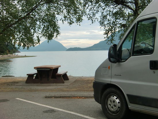 So herrlich standen wir auf dem Day-use-Platz in Porteau Cove. Wir entdeckten nirgends ein Schild, daß overnight verboten wäre; also blieben wir hier. Toilette, Wasser, Picknickbank und die schöne Aussicht gab es umsonst.