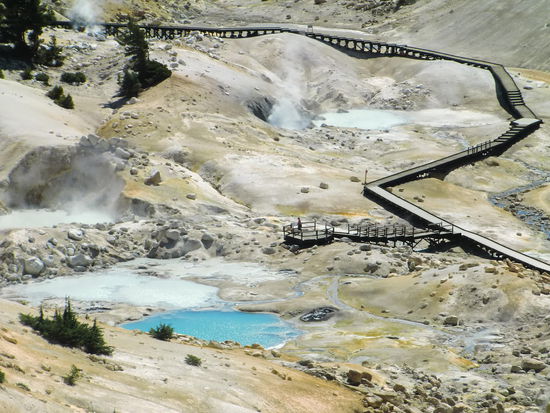 Erster Blick auf das Gebiet der Dämpfe und heißen blubbernden Gewässern!
Der Bordwalk führte sicher durch das 'heiße' Gebiet!
In der Mitte eine Aussichtsplattform auf der Gregor seine Kappe verlor, bzw. sie wurde vom Wind über die Brüstung geweht.
Ich hätte sie nie geholt da rechts und links direkt neben dem Bordwalk schon Löcher waren die heißen Dampf ausstießen.
Gregor holte seine Kappe nicht da auf einem Schild darauf hingewiesen wurde, daß es verboten sei den Steg zu verlassen!!!