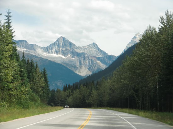 In Vernon bei Regenwetter abgefahren! Fahrt auf dem Hwy. 97 nach Revelstoke, oft am Ufer der Seen entlang. Dann kamen die Berge in Sicht und das Regenwetter verzog sich.
Unterwegs lag plötzlich in einer langgezogenen Kurve eine hölzerner Strommast auf der Strasse! Nachdem ein PKW auf der Gegenfahrbahn in der Mitte durch den gespaltenen Stamm gefahren ist, fuhr Gregor auch. Ich hätte echt Schiss gehabt daß auf der Leitung noch Strom ist!
