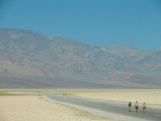Badwater: Die Salzflats
Das Salz sah auf der für die Touristen angelegten Trasse schon weiß aus - daneben war es aber gelblich und sah wie abgekippter Sand aus!
Wo die Fotos aus unserem Reiseführer gemacht wurden mit den herrlich weißen Salzen in Wabenform? Wir haben sie nicht gesehen!
Hier waren wir 85,5 m unter dem Meeresspiegel!
Und der Berg hinter uns warf noch Schatten auf den Parkplatz und unser Auto!