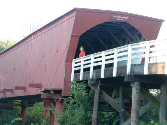 Ich - als 'Meryl Streep' auf der Roseman Bridge!
Den kleinen Ort in dessen Nähe die Francesca aus dem Film wohnte gab es auch.
Es wurde nur langsam dämmrig und wir fuhren lieber zur nächsten rest Area um dort zu übernachten.
Wir wunderten uns schon warum dort keine PKW standen.
Der Strassenlärm von der Autobahn war laut und hinter uns die Trucks. Na ja - ich habe ja Oropax!
Nachts stellten die Trucks dann alles zu - wirklich alles. Und dicht hinter uns waren zwei mit laufendem Motor der abwechselnd irrsinnig laut wurde. Gregor meinte, da s sei so eine Art Thermostat damit die Temperatur konstant gehalten wird!
Es war nicht zum Aushalten!
Nachts um 2 Uhr fuhren wir weiter zur nächsten Ausfahrt. Gespenstische Leere! Kein Auto weit und breit obwohl es einen 24 Std.Mäc gab. 
Die nächste Ausfahrt - das Gleiche!
Da entdeckte ich aber einen Supermarkt auf dessen Parkplatz einige PKW standen. Wir stellten uns in eine Ecke und schliefen beide sofort ein!