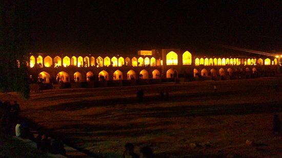 Die bei Nacht beleuchtete Khaju Brücke (Pol-e Chadschu) in Esfahan. Die Brücke führt über den Zayandeh Rud und verbindet zwei Stadtteile Isfahans. Sie ist zweistöckig und hat 23 Backsteinbögen.