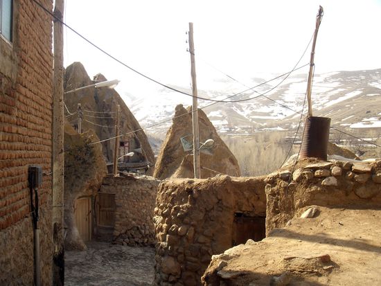 Kandovan Dorfszene mit den umliegenden schneebeckten kargen Bergen des Sahand-Gebirges.