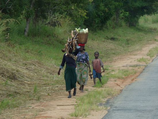 die Lasten werden auf dem Kopf getragen und die Babys auf dem Ruecken