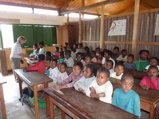 es sitzen jeweils vier Kinder in einer Bank für eigentlich Zwei