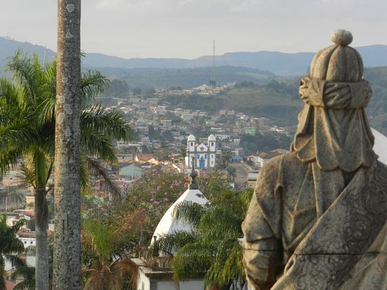 wir blicken einbem Apostel über die Schulter auf die Stadt Congonhas