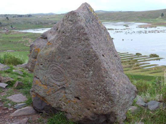 Ein Stein, der wie ein Puma-Gesicht geformt ist mit Petroglyphen