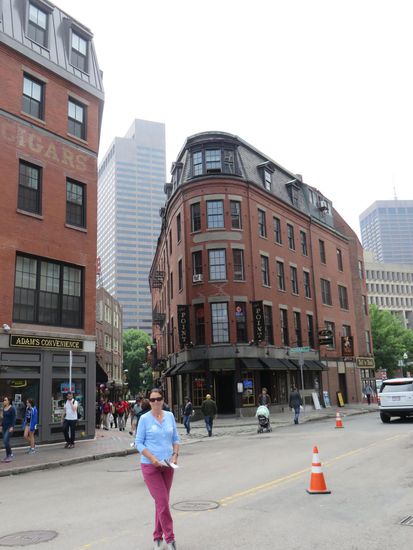 Ein altes Eckhaus und dahinter der moderne Wolkenkratzer.