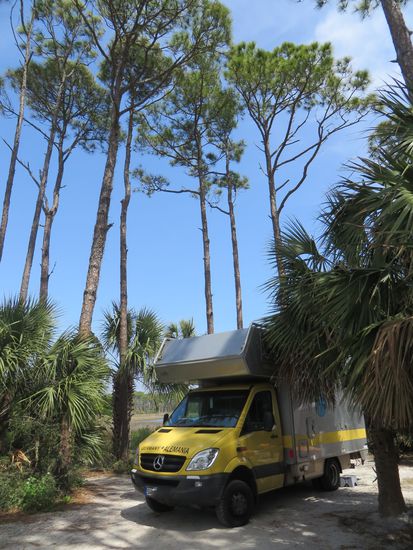 Wir bekamen einen schönen Stellplatz unter Kiefern. Dieser Platz ist so ganz anders, als der in Carrabelle. Dort war alles ganz ordentlich und gerade, der Boden zementiert, hier sind wir jetzt mitten in der Natur direkt auf Sandboden. Das Wetter ist noch schön, so daß wir draußen essen.