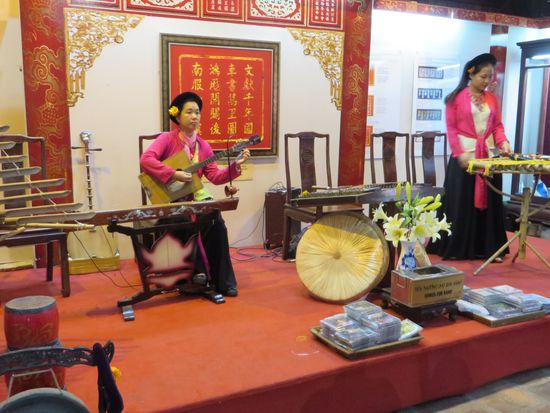 Drei Mädchen machen Musik auf vietnamesischen Musikinstrumenten, wir bleiben eine Weile sitzen und hörten zu.