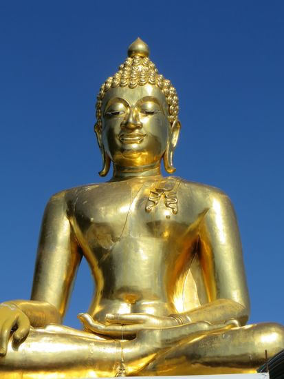 der goldene Buddha lächelt milde auf die vielen Touristen herab